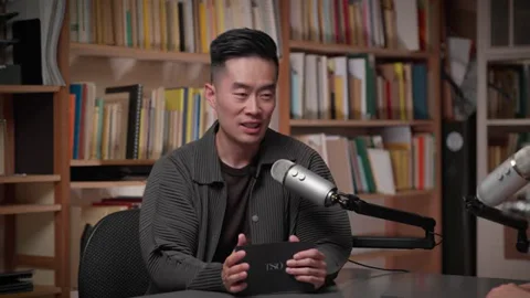 Hezekiah Leung speaking with Luri Lee across podcast microphones